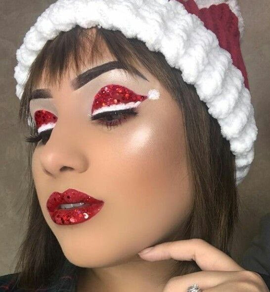 Con sombra de ojos de color rojo maquilla los párpados y con delineador blanco haz los retoques para hacer el gorro de Santa Claus